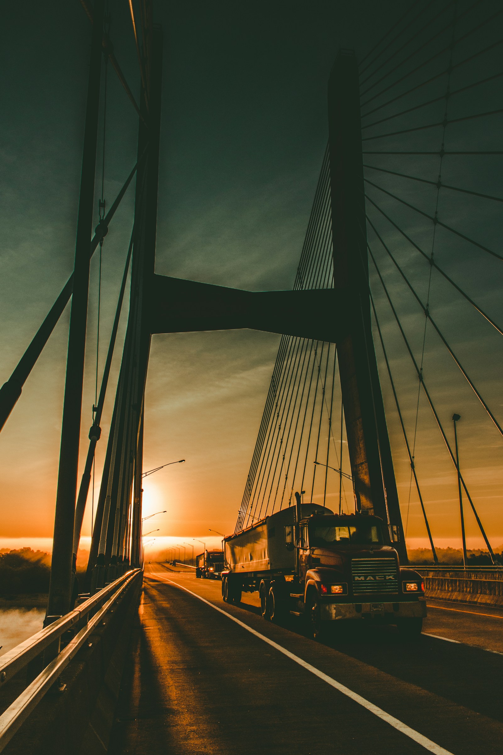 Tractocamión cruzando un puente durante el amanecer